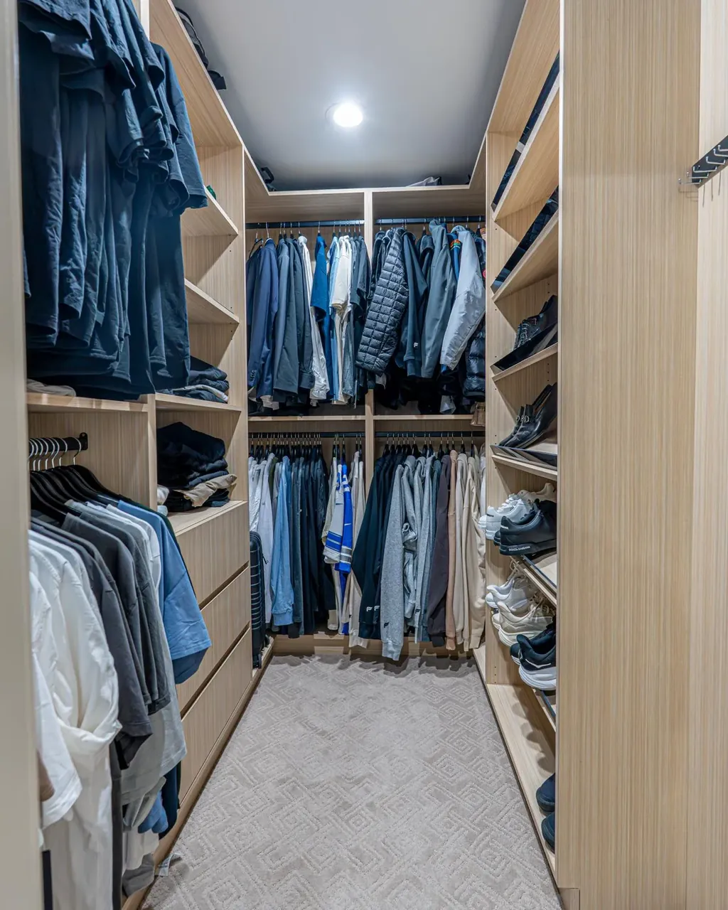 Light wood walk-in closet with hanging rods on three sides and open shelving by Mason Oak Carpentry in Detroit, MI