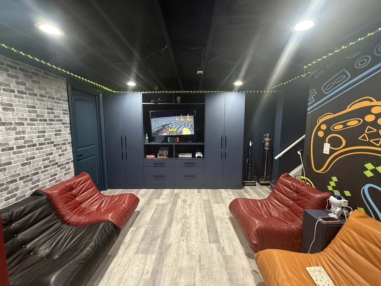 Navy media wall with built-in cabinets in a game room by Mason Oak Carpentry in Detroit, MI