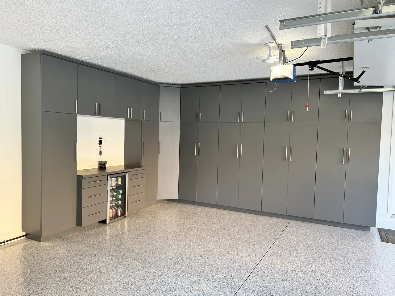 Garage wall of gray tall cabinets with a lit beverage nook by Mason Oak Carpentry in Detroit, MI