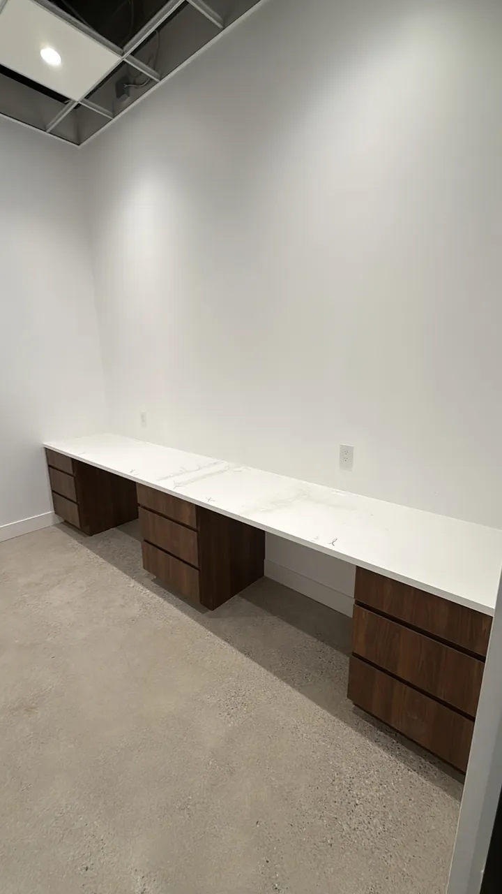 Office desk run with walnut drawer pedestals and a white stone top by Mason Oak Carpentry in Detroit, MI