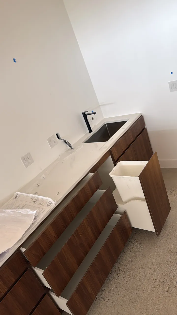 Walnut base cabinets with a pull-out bin and an undermount sink by Mason Oak Carpentry in Detroit, MI