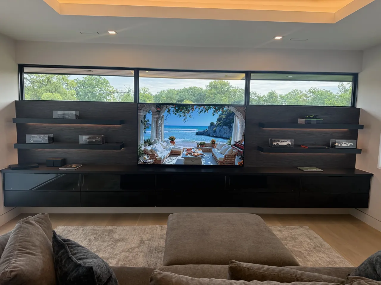 Floating black media wall with open shelving under a run of windows by Mason Oak Carpentry in Detroit, MI