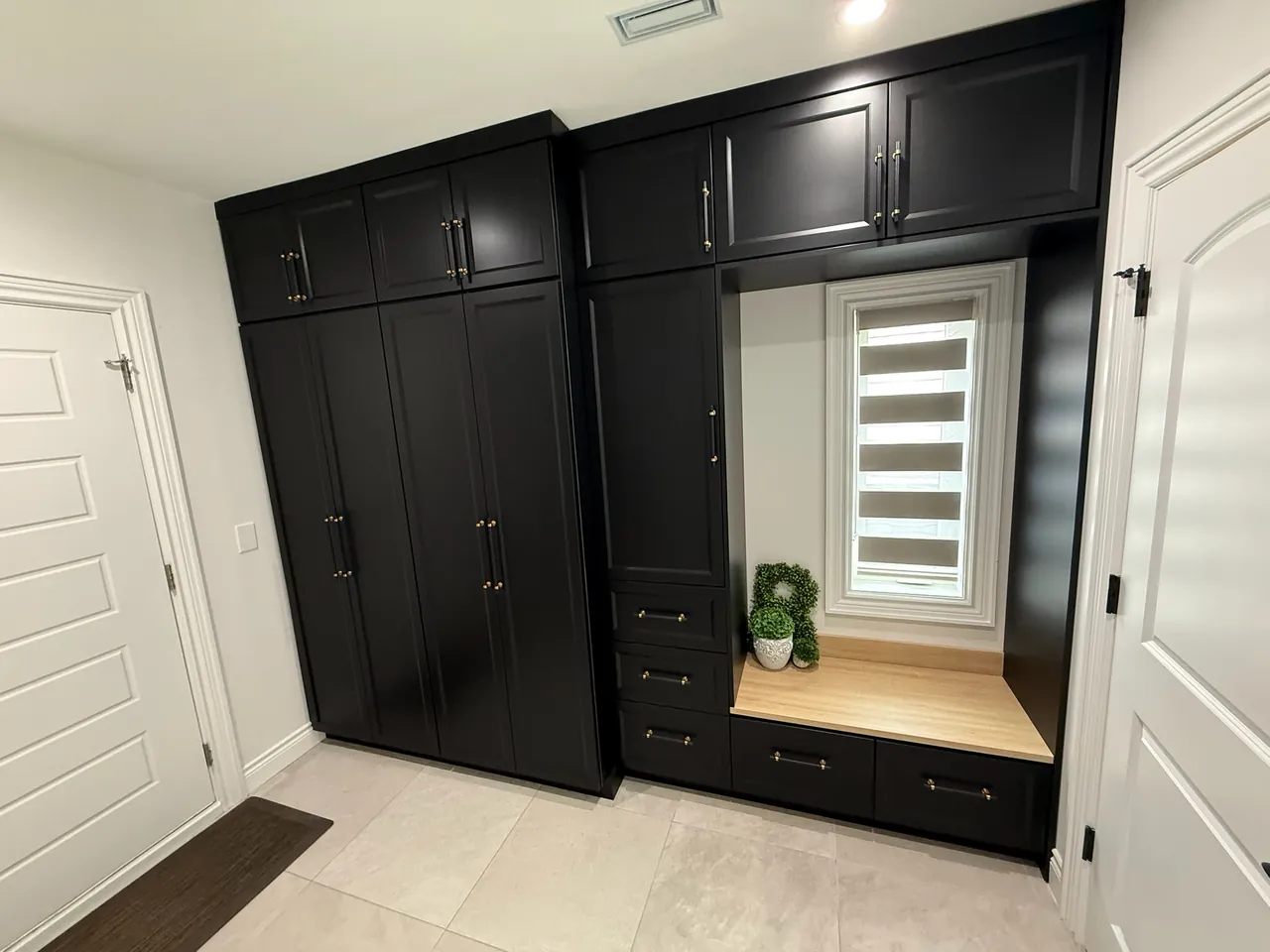 Black mudroom cabinets with a built-in bench and drawers by Mason Oak Carpentry in Detroit, MI