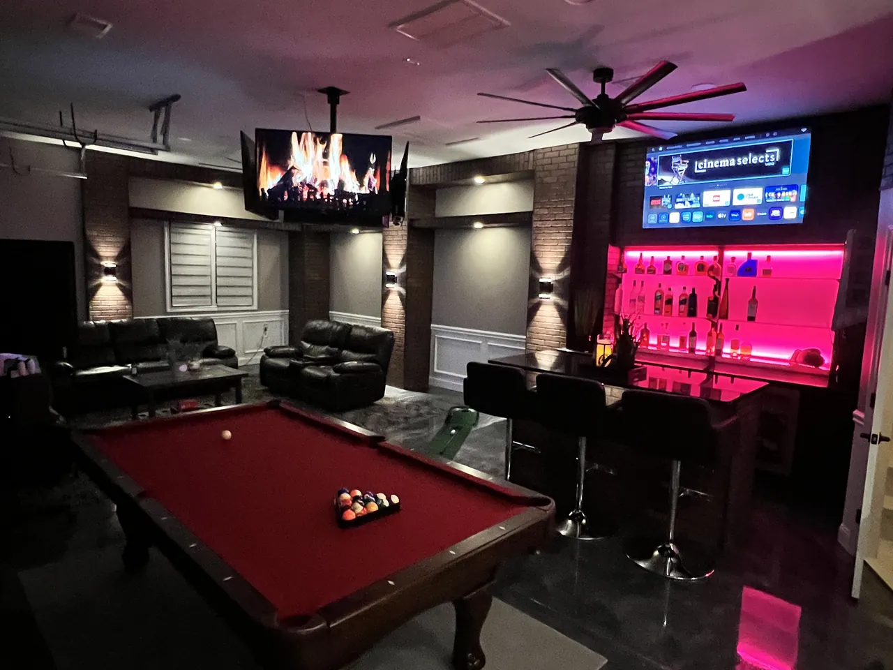 Garage game room with a lit back bar and built-in shelving by Mason Oak Carpentry in Detroit, MI
