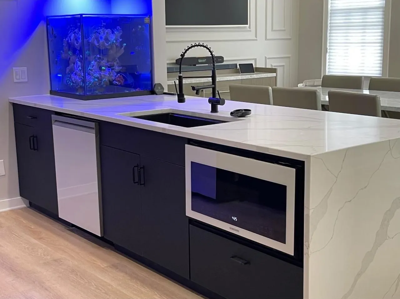 Black cabinet run with a waterfall quartz countertop and a built-in microwave by Mason Oak Carpentry in Detroit, MI