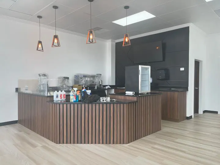 Coffee shop counter with a vertical wood slat front and black cabinetry behind it by Mason Oak Carpentry in Detroit, MI