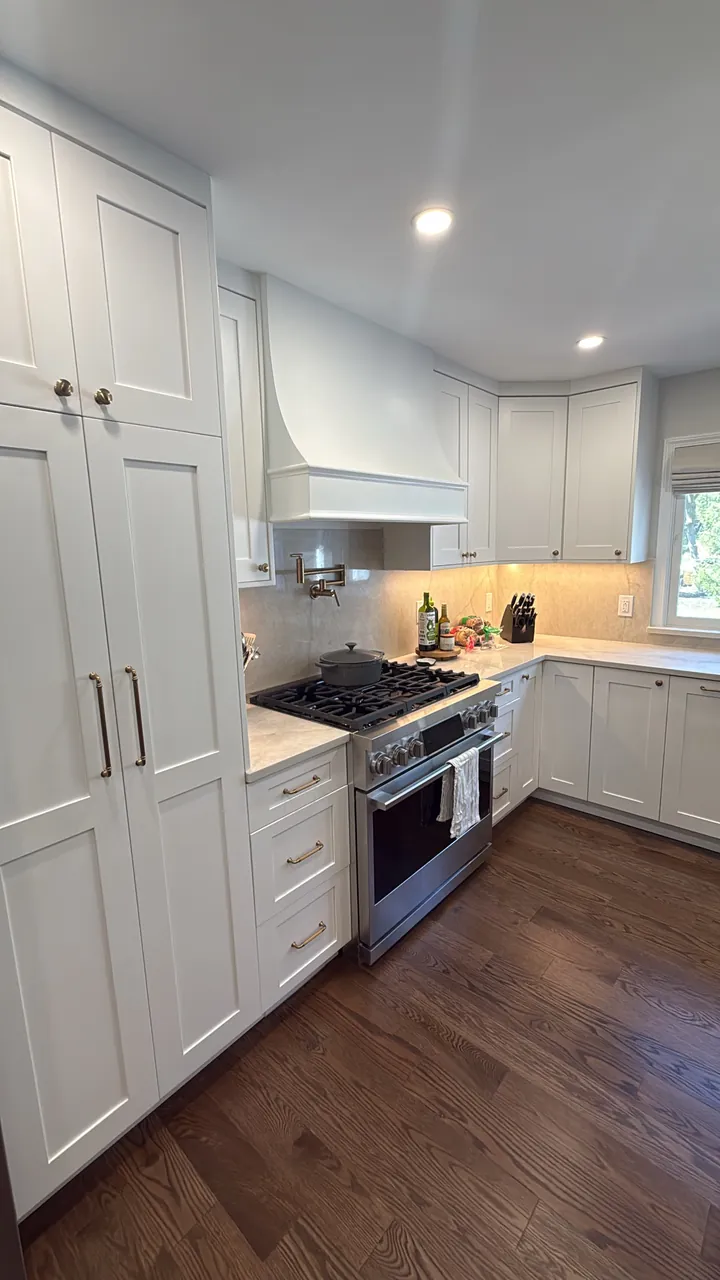 White shaker kitchen with a tall pantry, a plaster range hood and a professional range by Mason Oak Carpentry in Detroit, MI