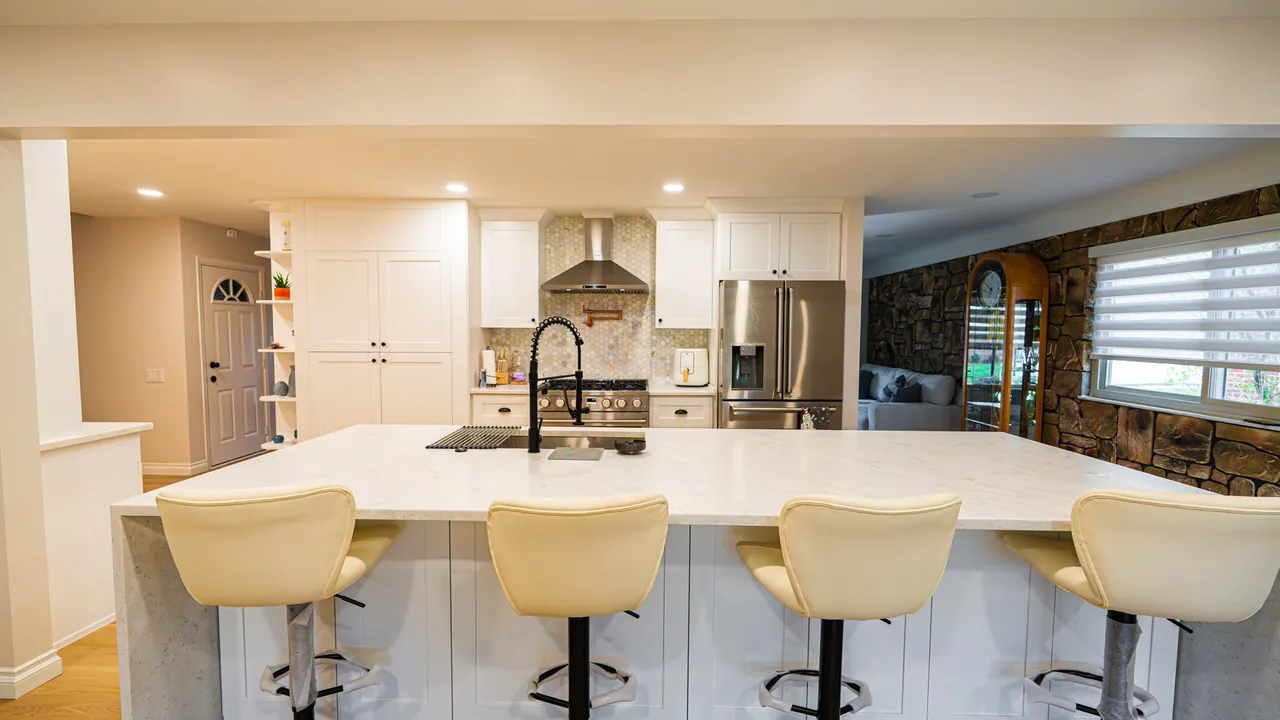 White kitchen with a waterfall island and seating for four by Mason Oak Carpentry in Detroit, MI