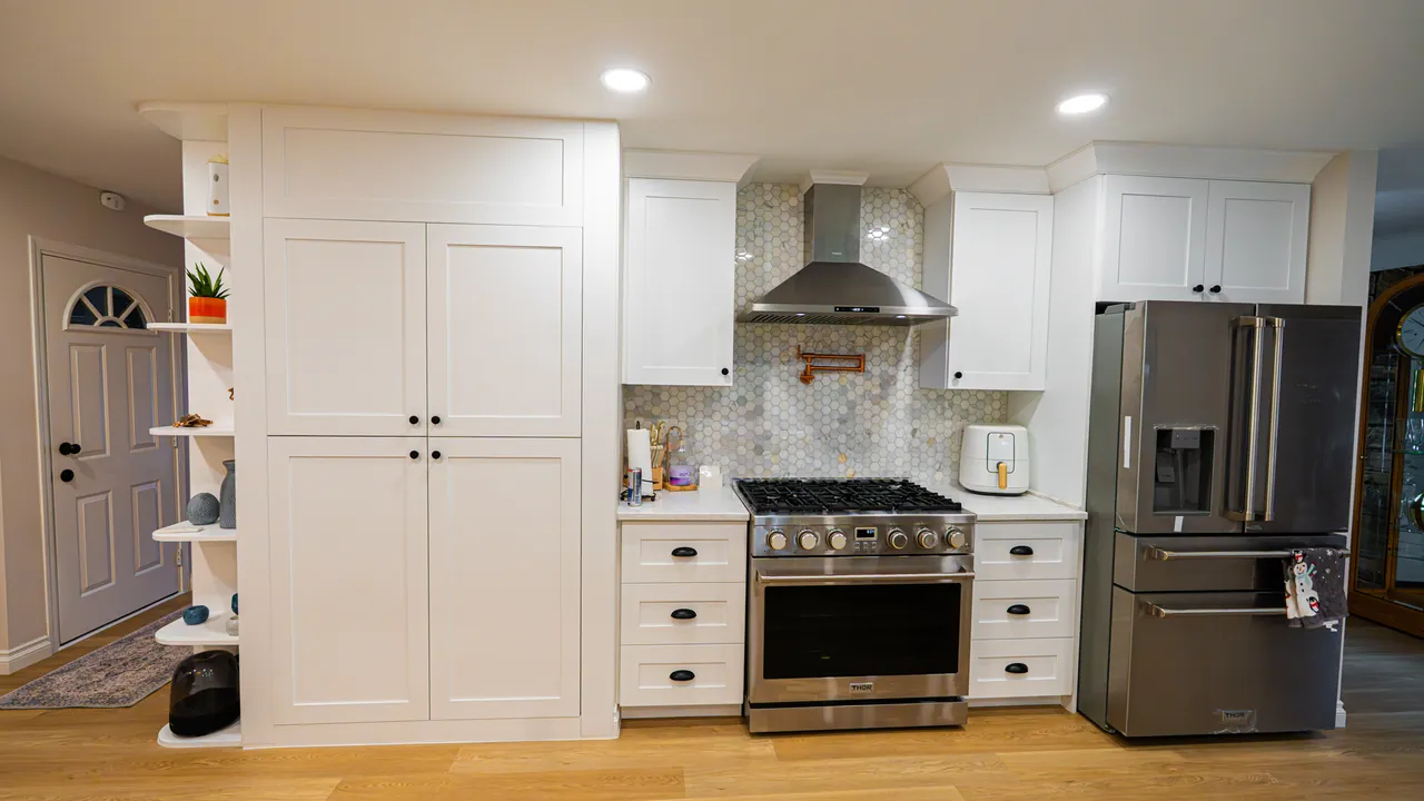 White shaker kitchen with a tall pantry, open end shelves and a stainless range by Mason Oak Carpentry in Detroit, MI