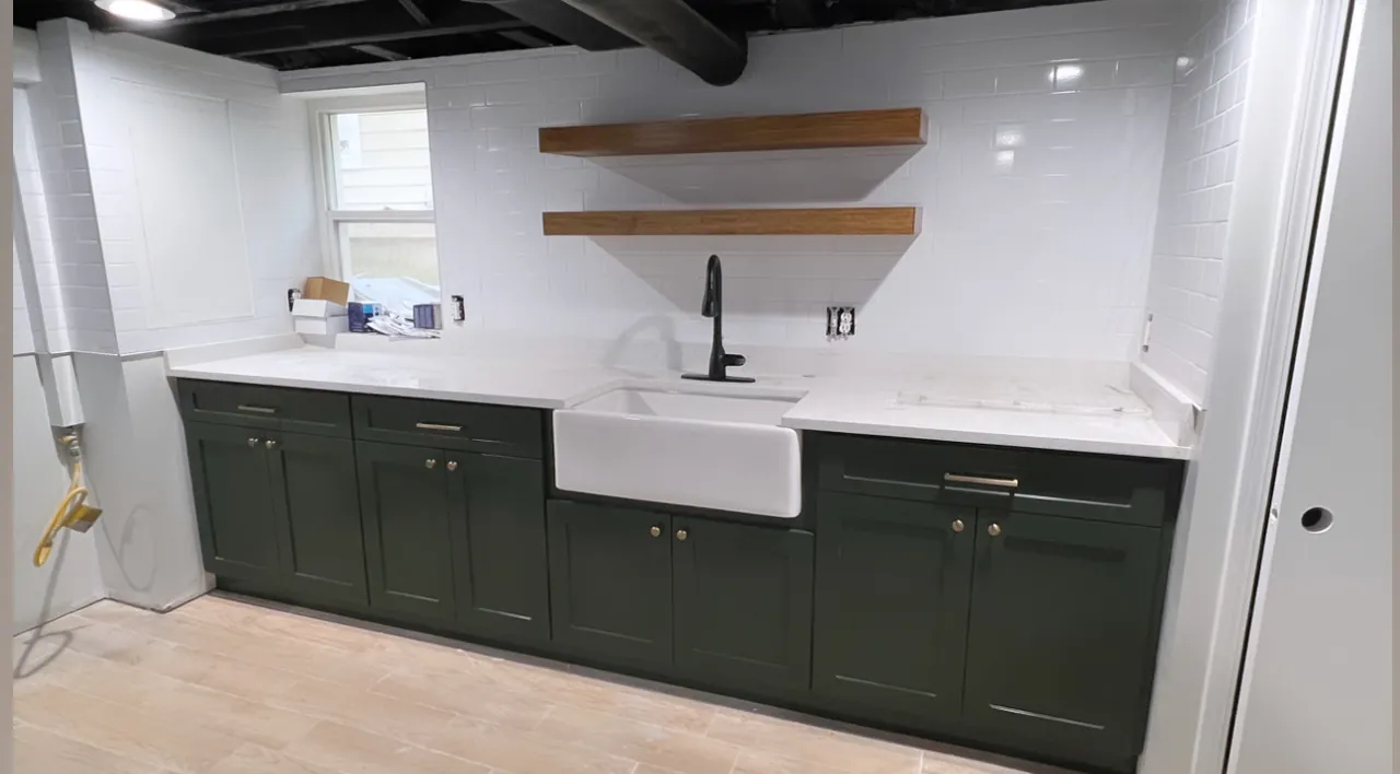 Green cabinets with a farmhouse sink and floating wood shelves by Mason Oak Carpentry in Detroit, MI