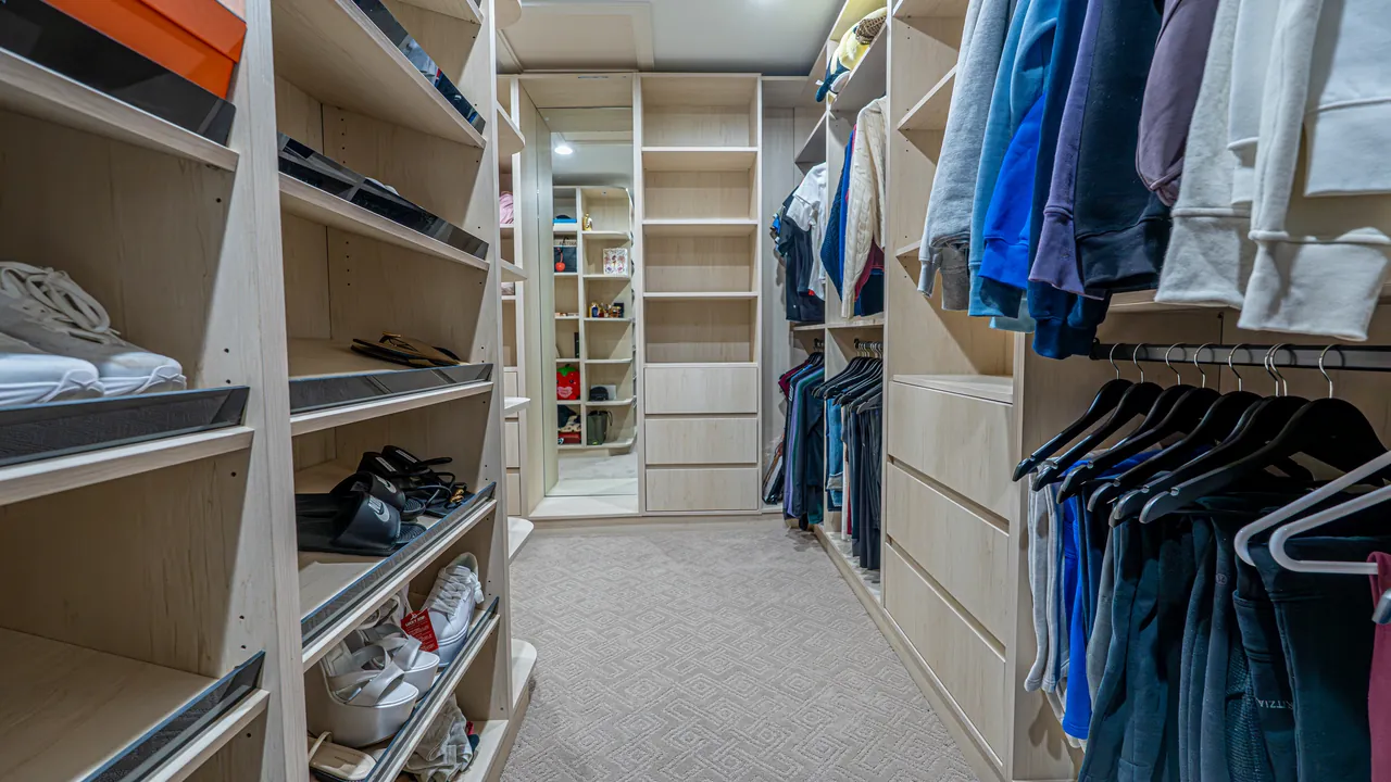 Light wood walk-in closet with shoe shelves and double hanging by Mason Oak Carpentry in Detroit, MI
