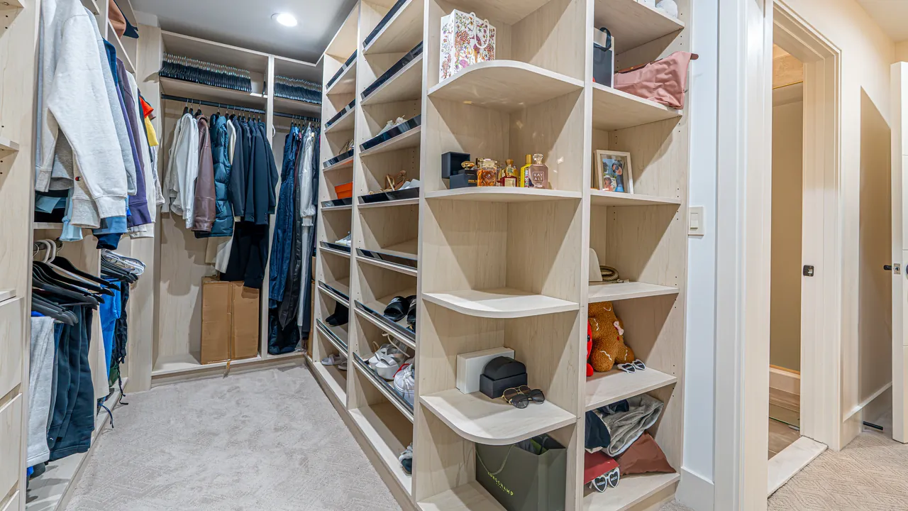 Light wood walk-in closet with curved corner shelves by Mason Oak Carpentry in Detroit, MI