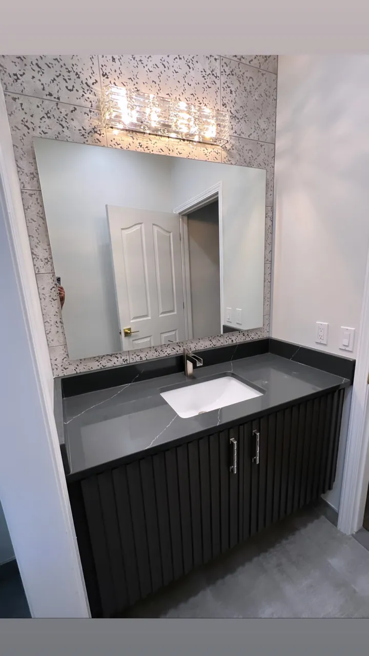 Black fluted vanity with a gray stone top by Mason Oak Carpentry in Detroit, MI