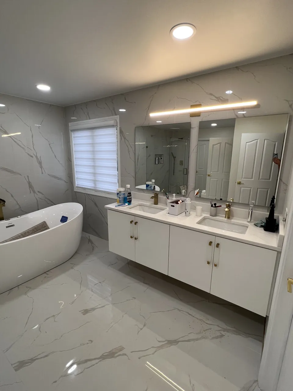 White floating double vanity beside a freestanding tub by Mason Oak Carpentry in Detroit, MI