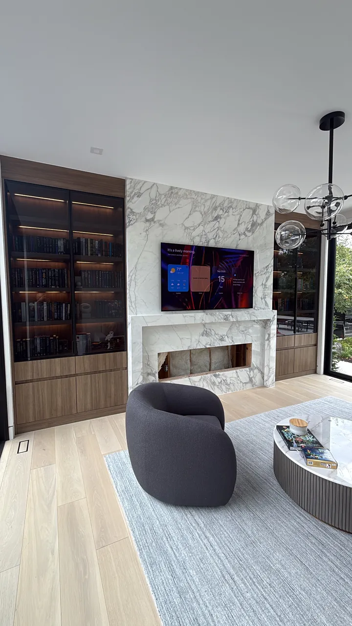 Fireplace wall with walnut cabinets and lit glass display shelves by Mason Oak Carpentry in Detroit, MI