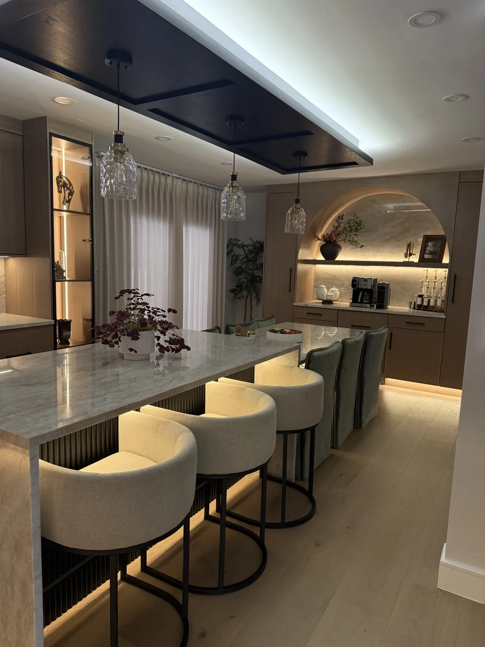 Kitchen with a long island, lit bar seating, glass cabinets and an arched coffee niche by Mason Oak Carpentry in Detroit, MI