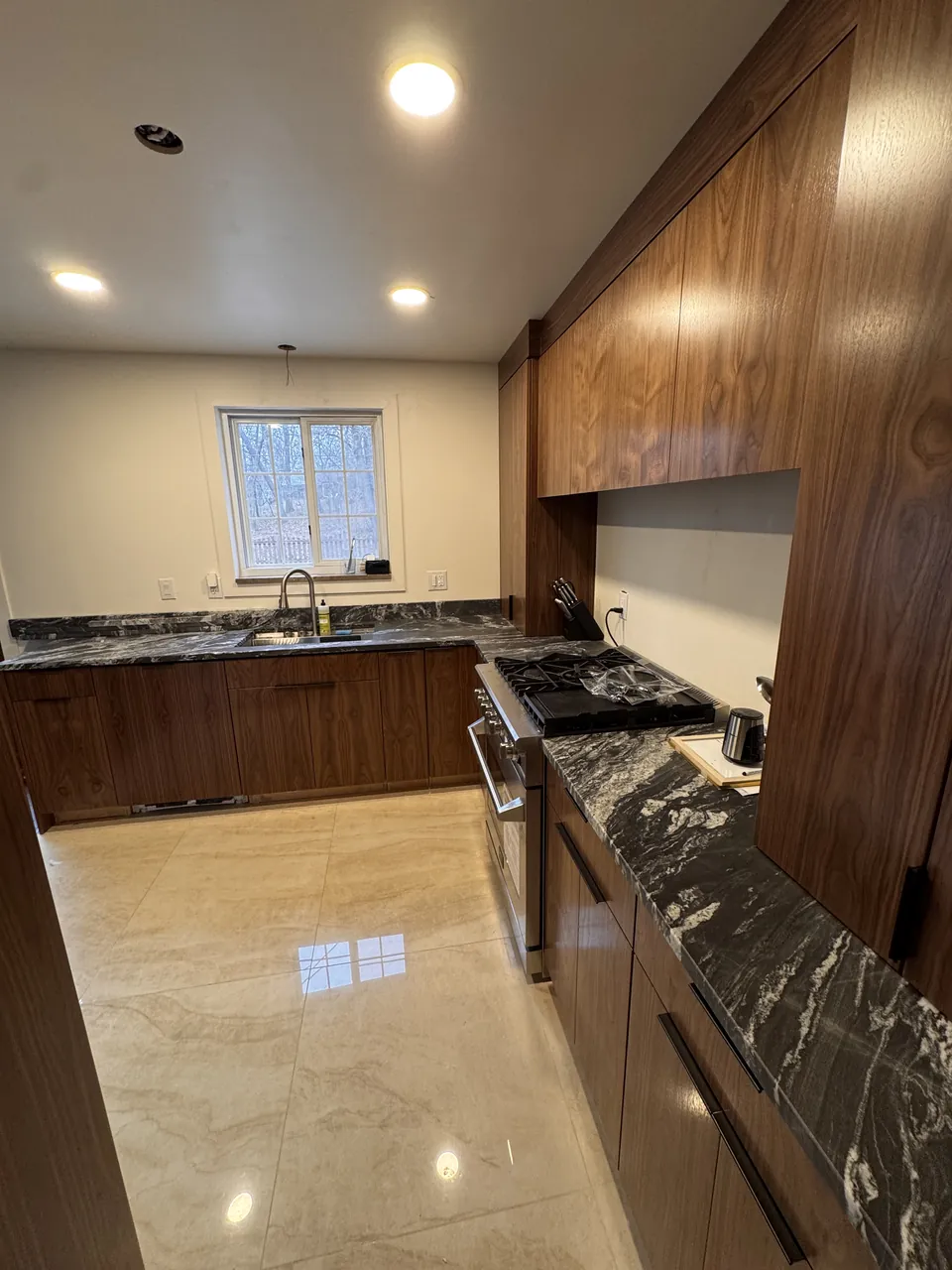 Walnut kitchen with tall cabinets and a black granite countertop by Mason Oak Carpentry in Detroit, MI