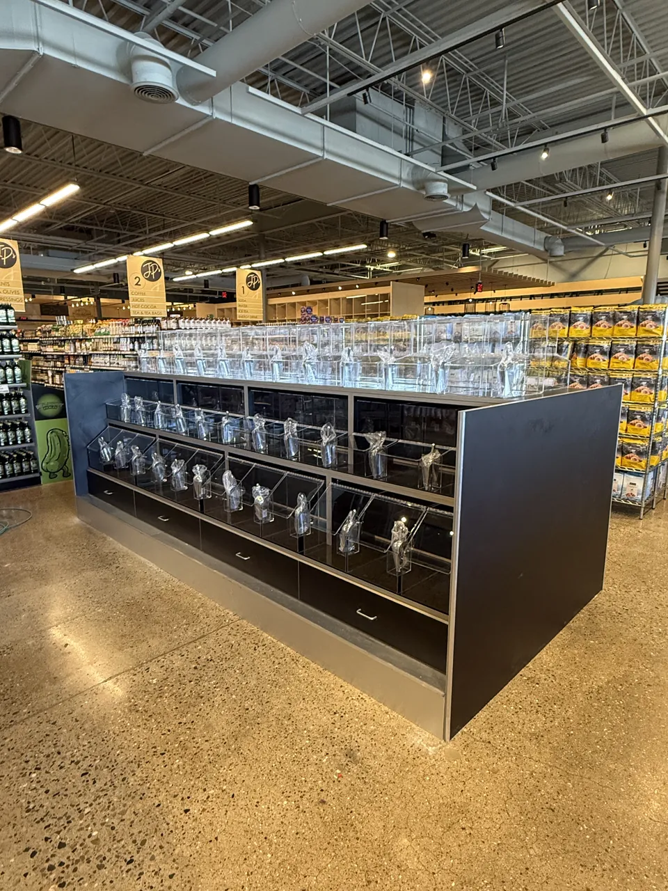 Retail display island with black cabinetry and glass jar shelving by Mason Oak Carpentry in Detroit, MI