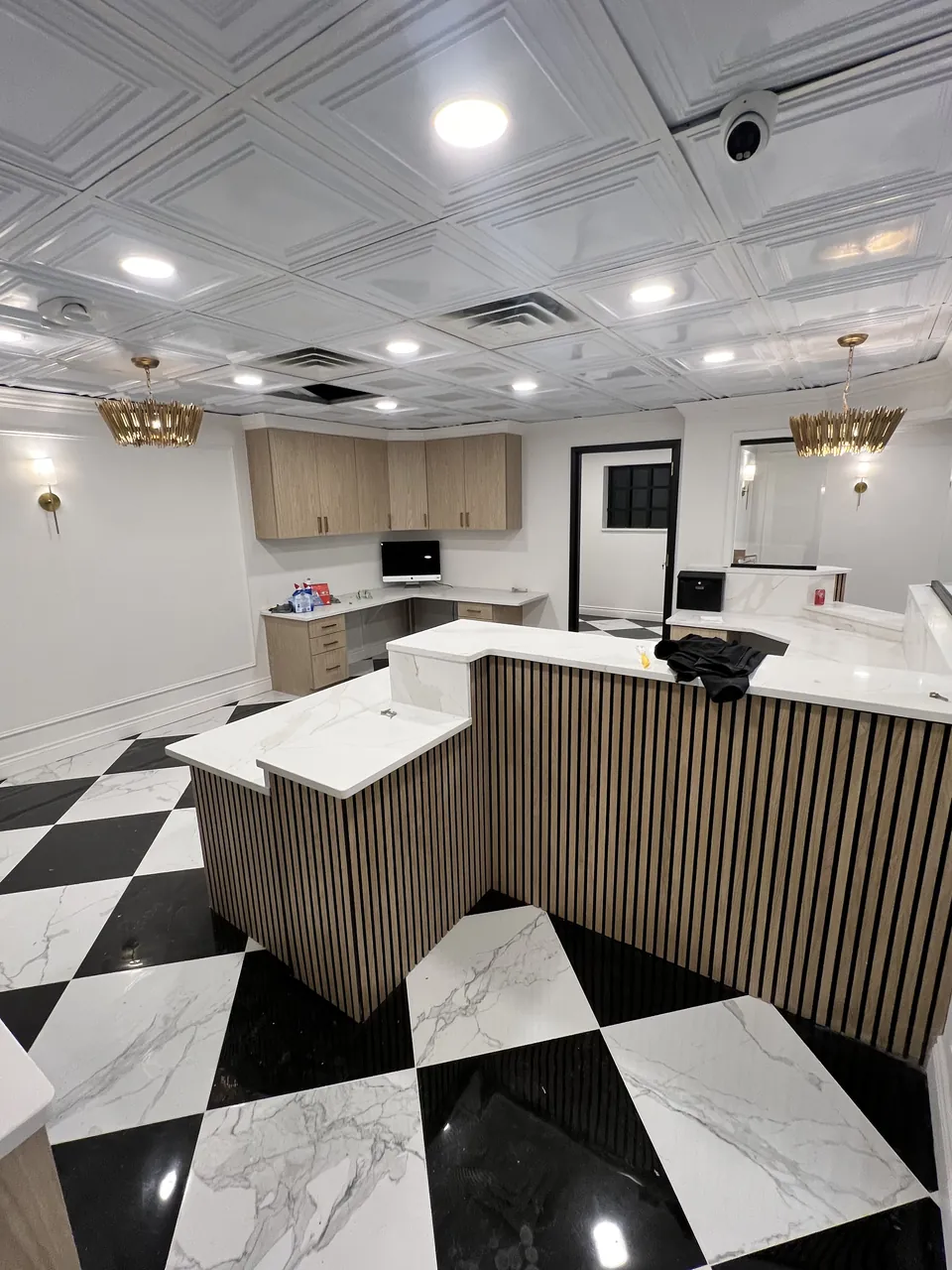 Reception desk with a vertical slat front on a checkerboard floor by Mason Oak Carpentry in Detroit, MI